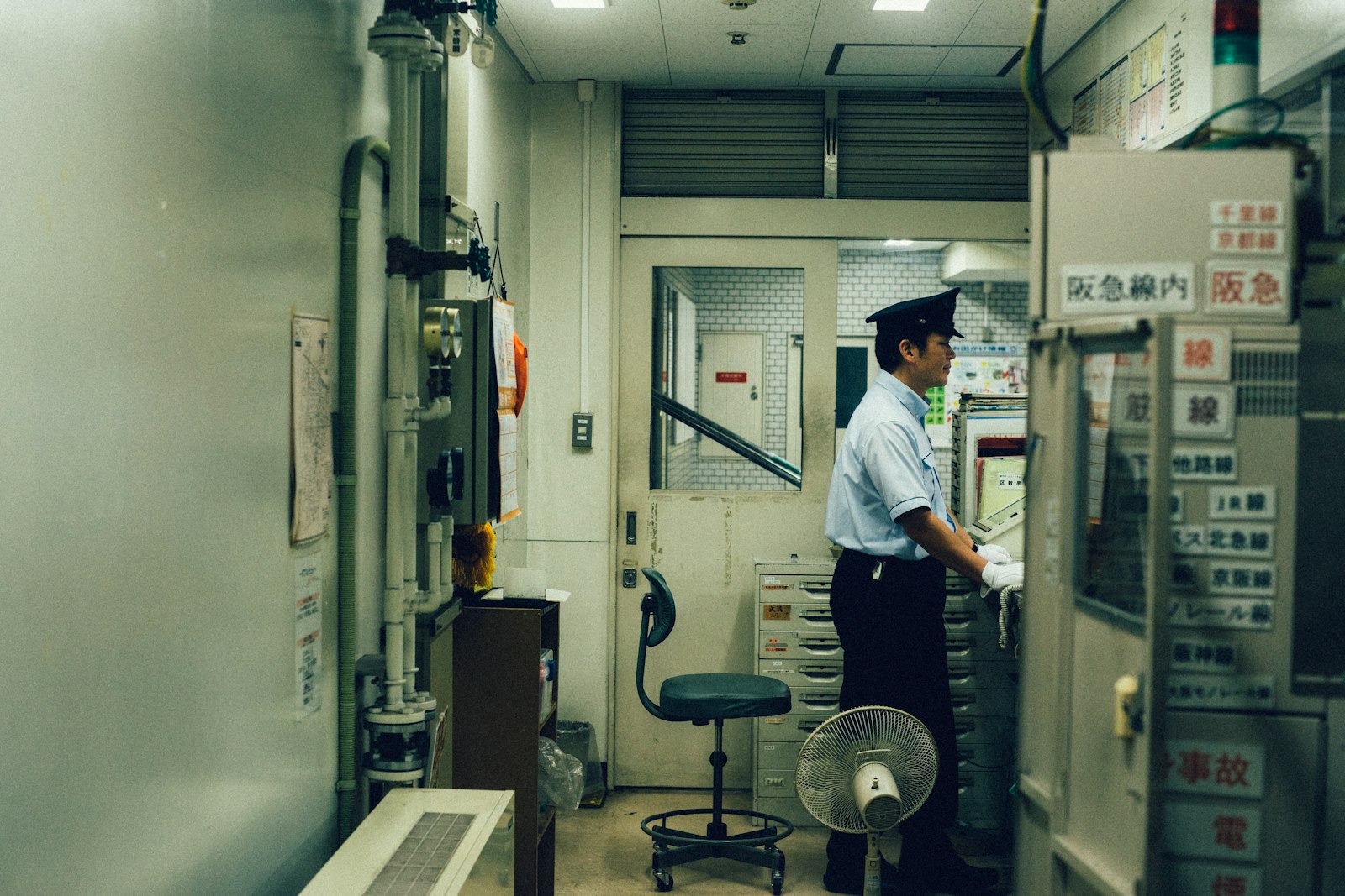 制御室で制御盤を確認する制服姿の係員（大阪、イメージ写真）