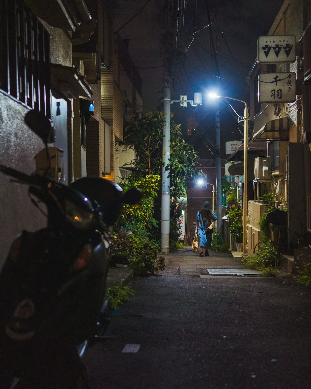 夜の住宅地の路地と駐車した二輪車（イメージ写真）