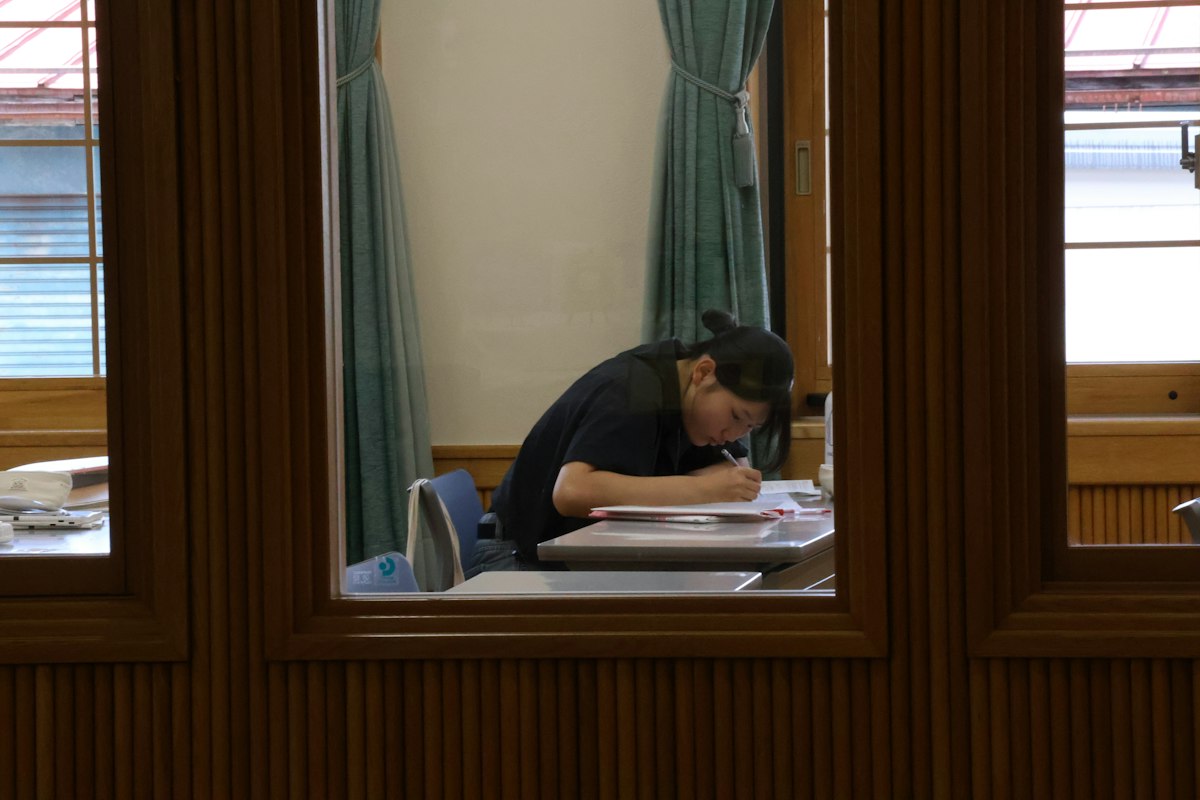机でメモを書く人（イメージ写真）
